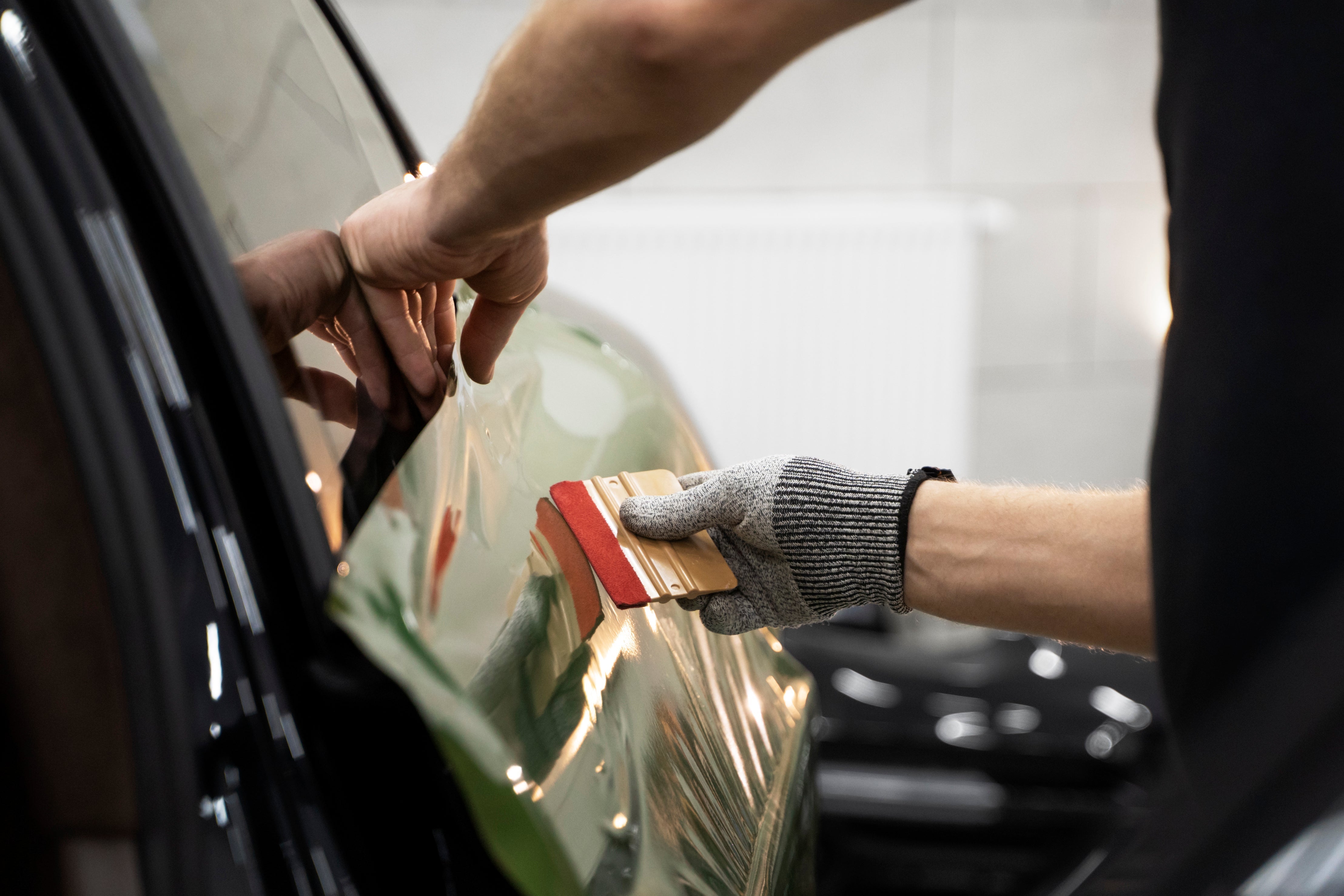 Installing car vinyl wrap using a vinyl squeegee