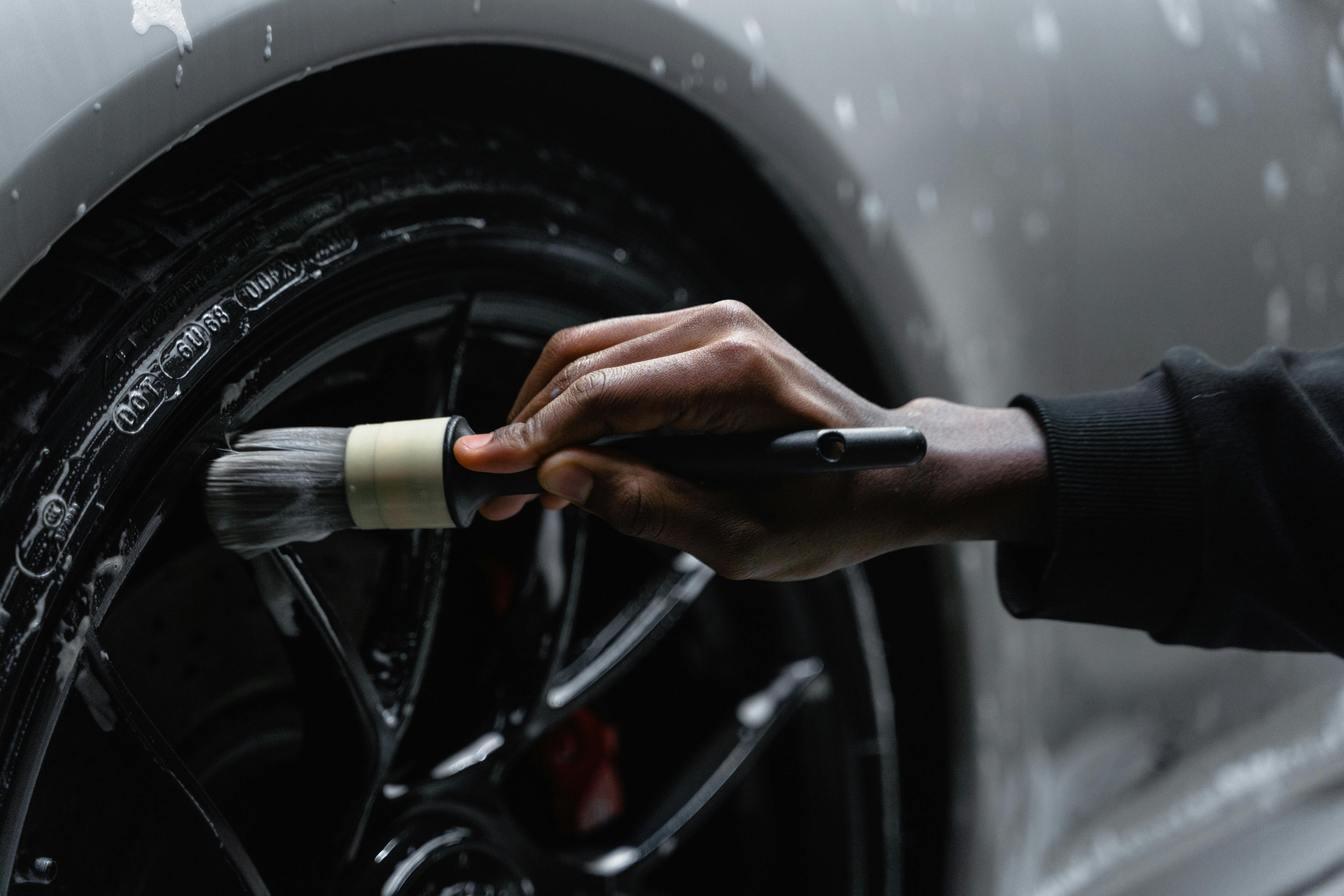 Car detailer using a detailing brush on tires