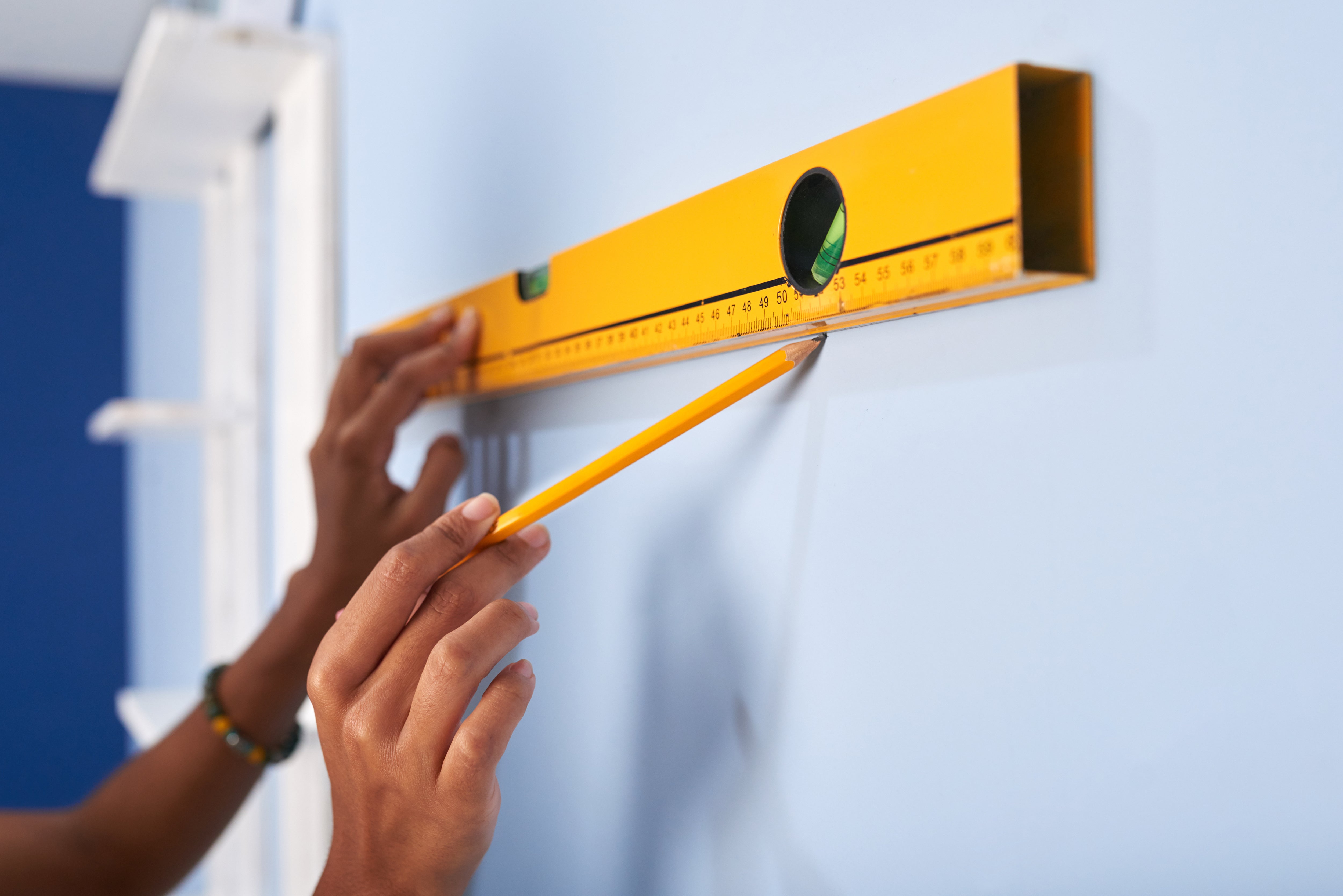 Installer measuring placement of wall lettering.